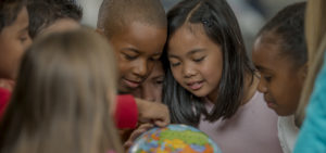 Diverse group of children looking at world globe