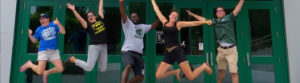 Staff fun jumping group picture outside of Binghamton University